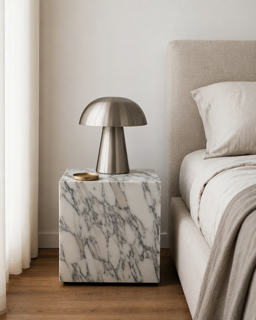 Luxury white marble cube with grey veining pattern placed next to a neutral tone bed with curtains in a modern Australian bedroom.