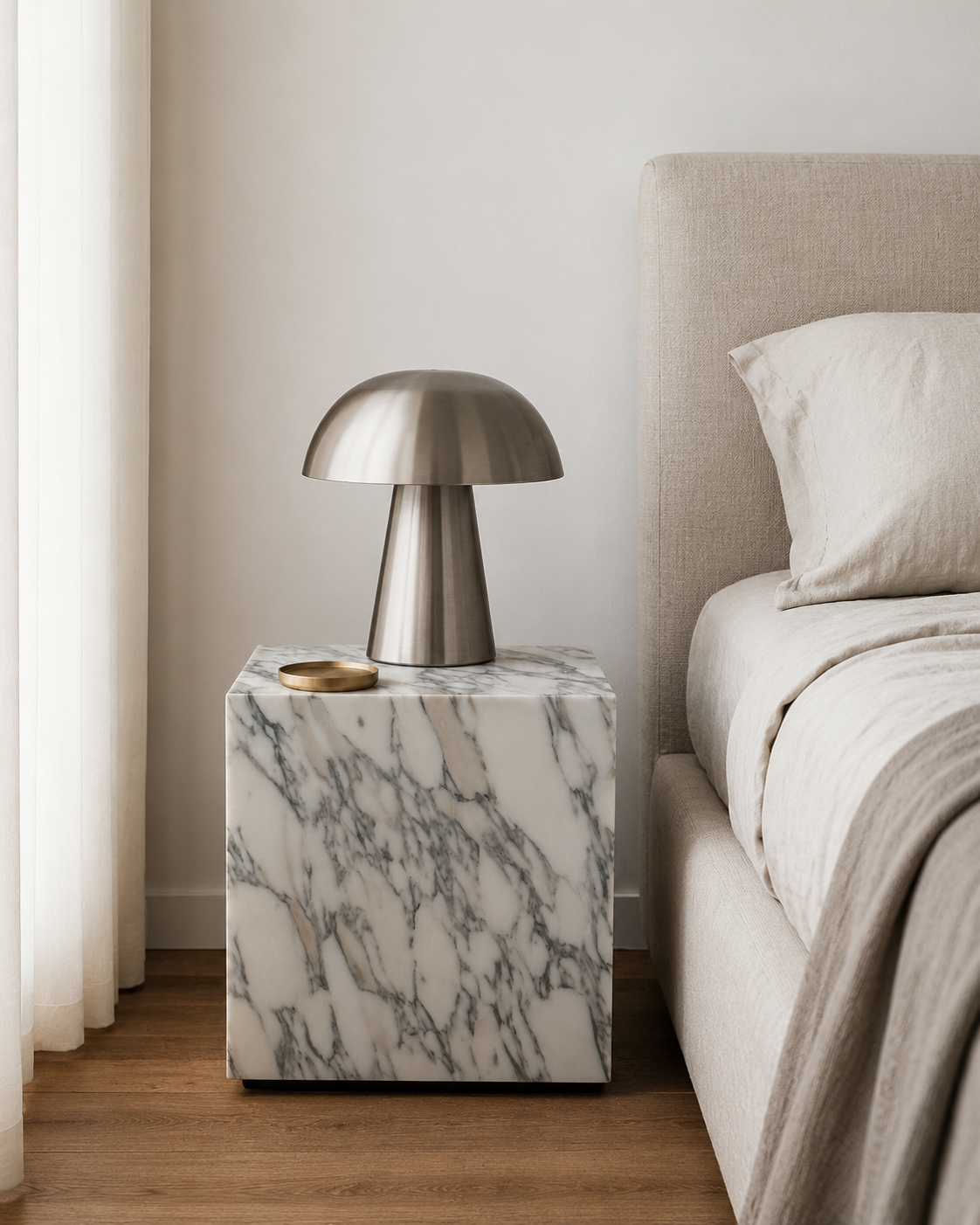 Luxury white marble cube with grey veining pattern placed next to a neutral tone bed with curtains in a modern Australian bedroom.