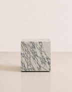 Luxury white marble cube with grey veining pattern rectangular block on a off white studio background. Front view.