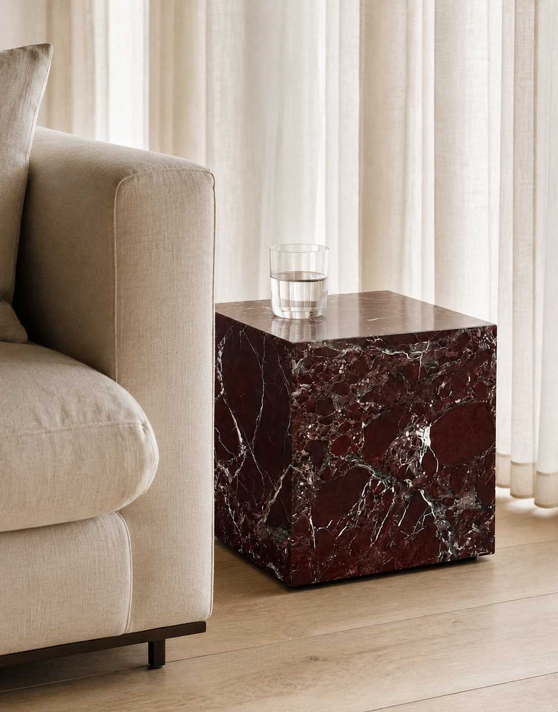 Luxury deep burgundy marble with delicate white veining pattern cube side table, next to a beige sofa in a modern Australian living room.
