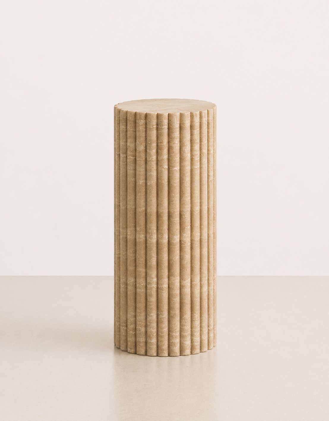 A medium fluted beige travertine plinth with natural grain texture placed in a beige studio. Front view.