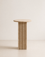 Beige travertine side table with a ribbed cylindrical design n a beige background
