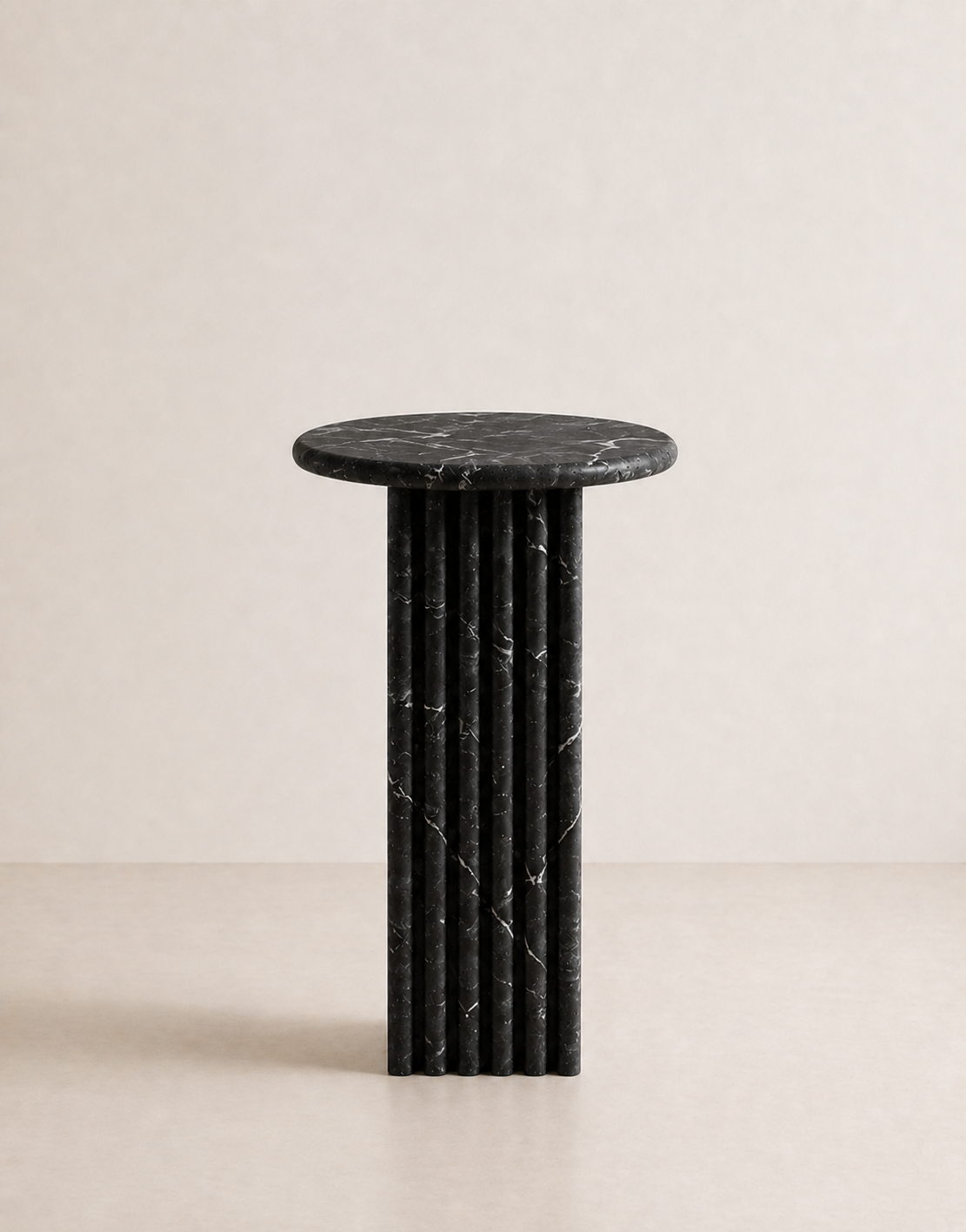 Black marble side table with a ribbed cylindrical design n a beige background