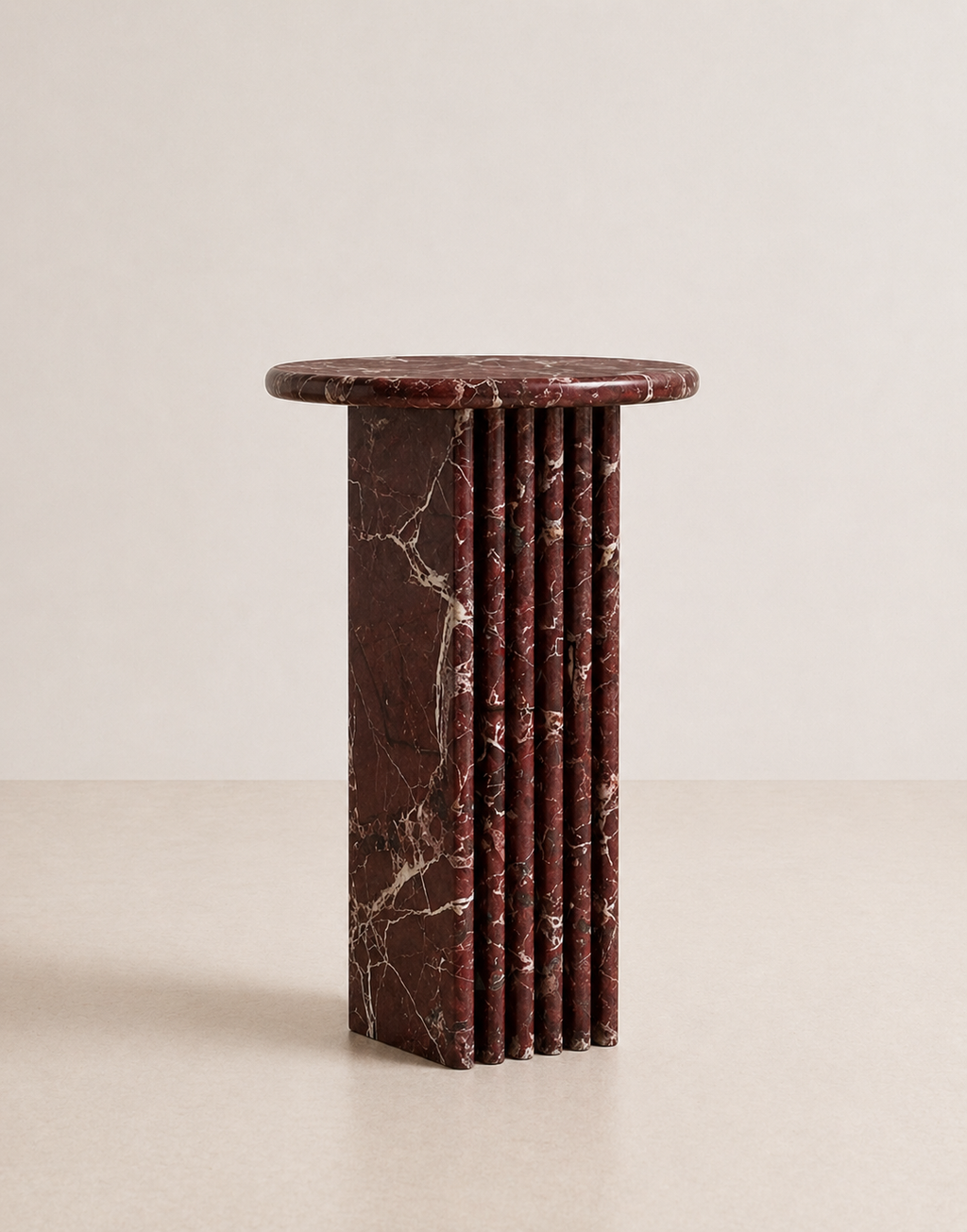 Luxury burgundy red marble side table with a ribbed cylindrical design in a beige background
