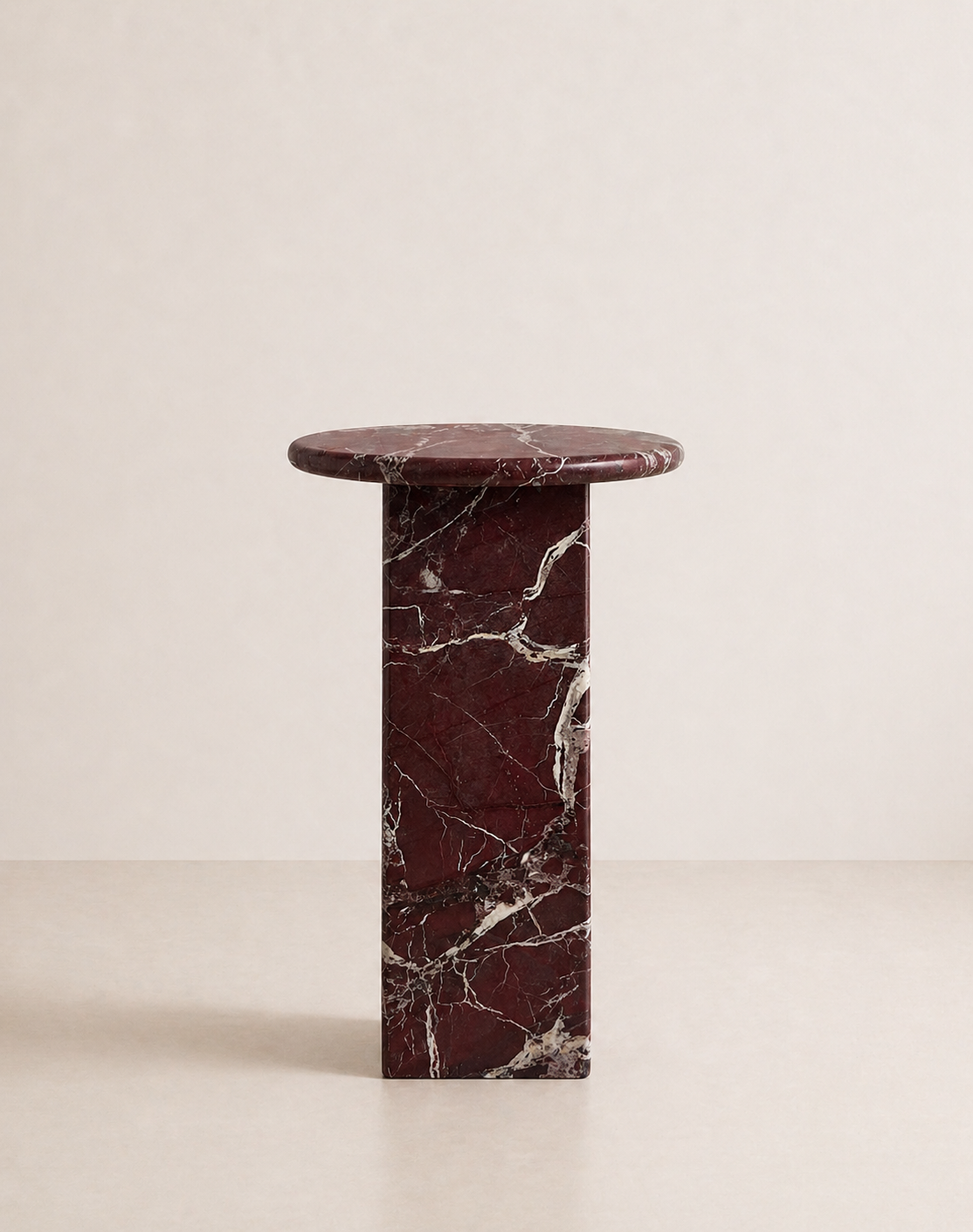 Luxury burgundy red marble side table with a ribbed cylindrical design in a beige background