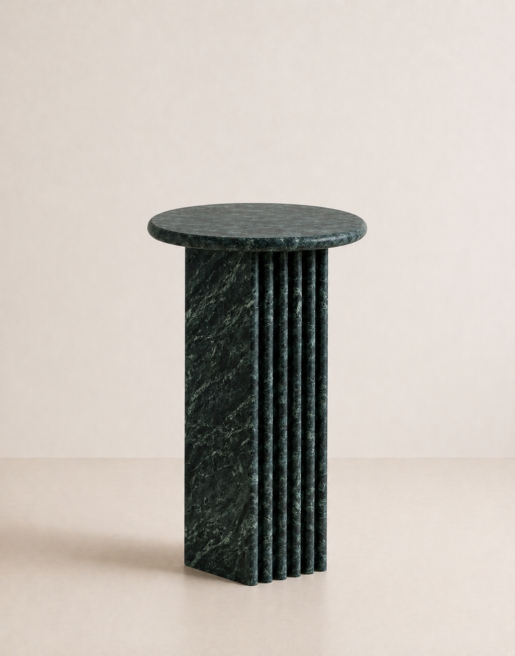 Emerald green marble side table with a ribbed cylindrical design n a beige background