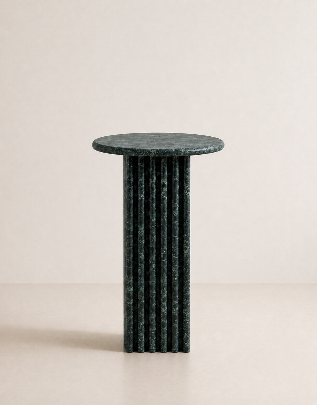 Emerald green marble side table with a ribbed cylindrical design in a beige background