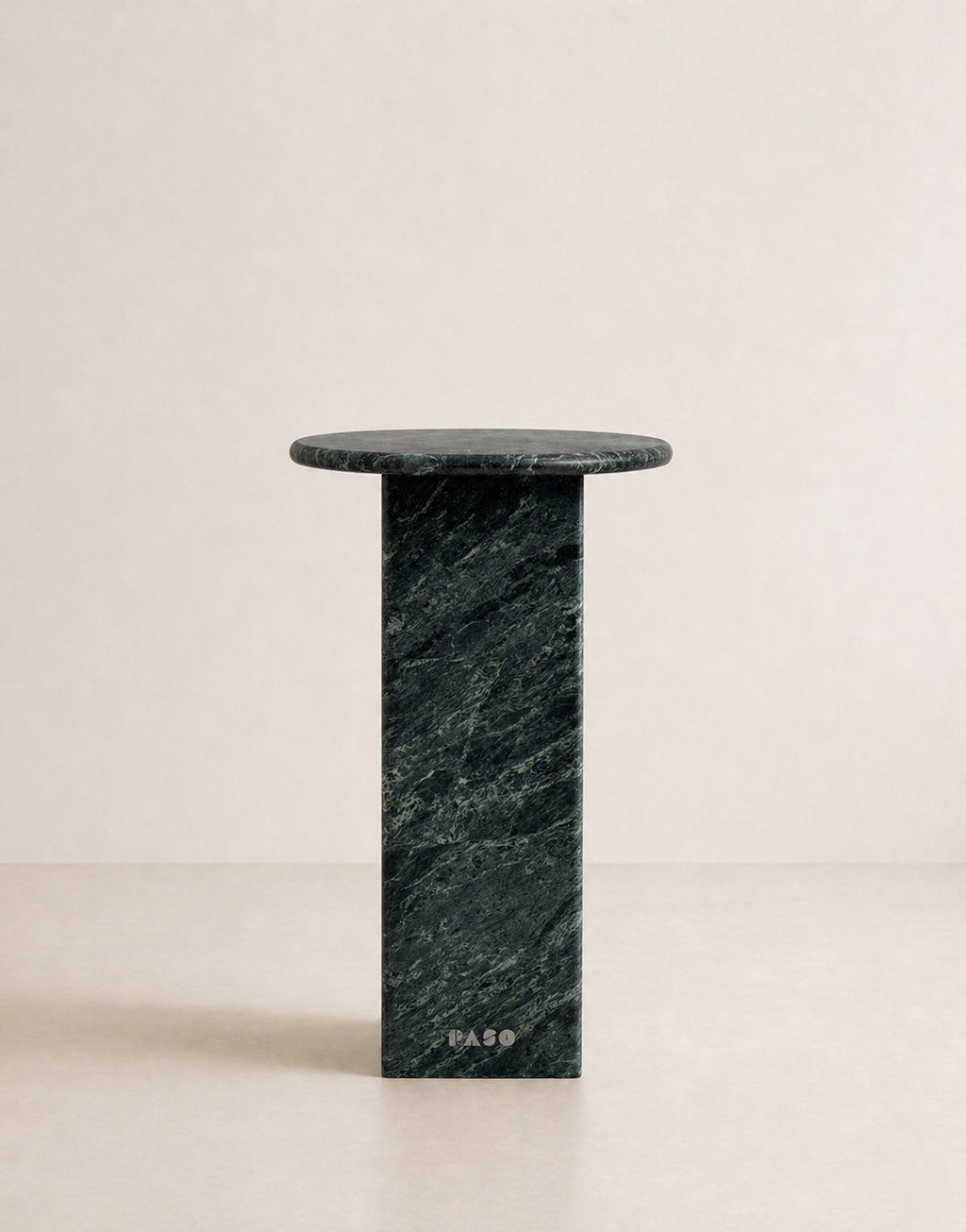 Emerald green marble side table with a ribbed cylindrical design n a beige background