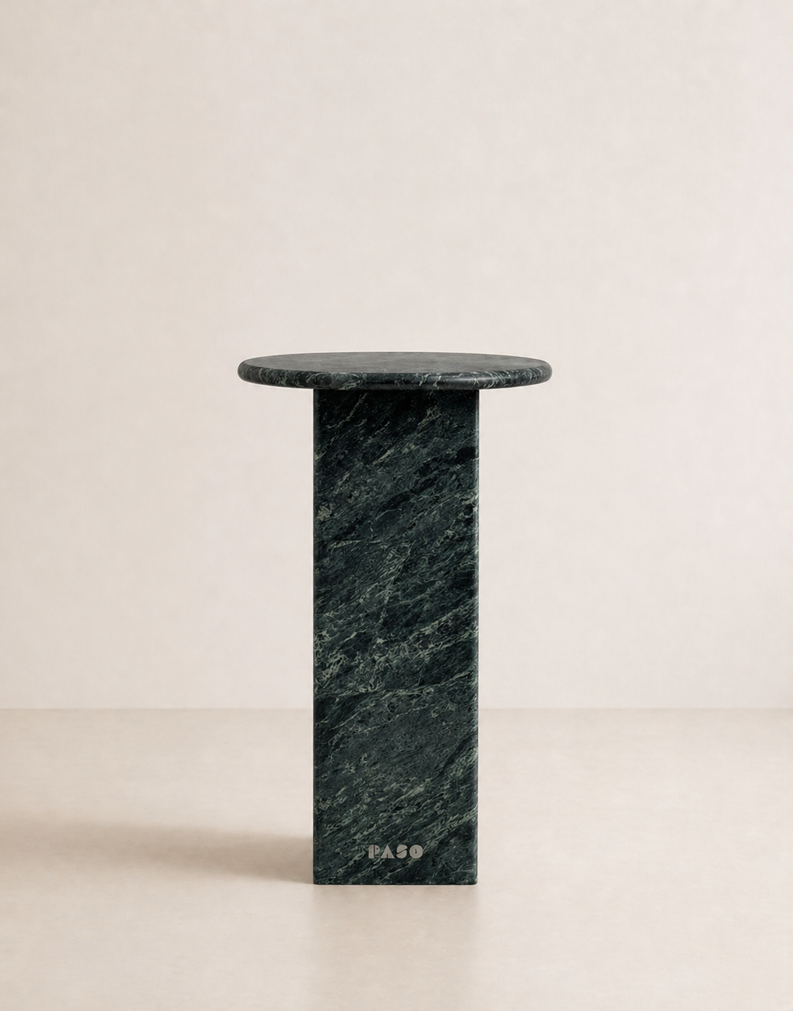 Emerald green marble side table with a ribbed cylindrical design n a beige background