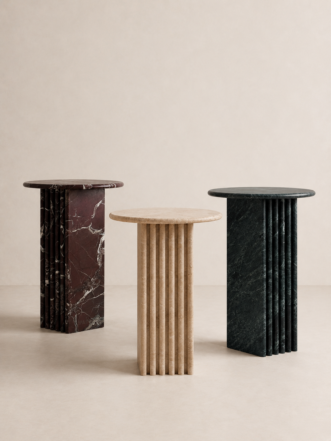 Three marble side tables with different colour patterns on a beige background