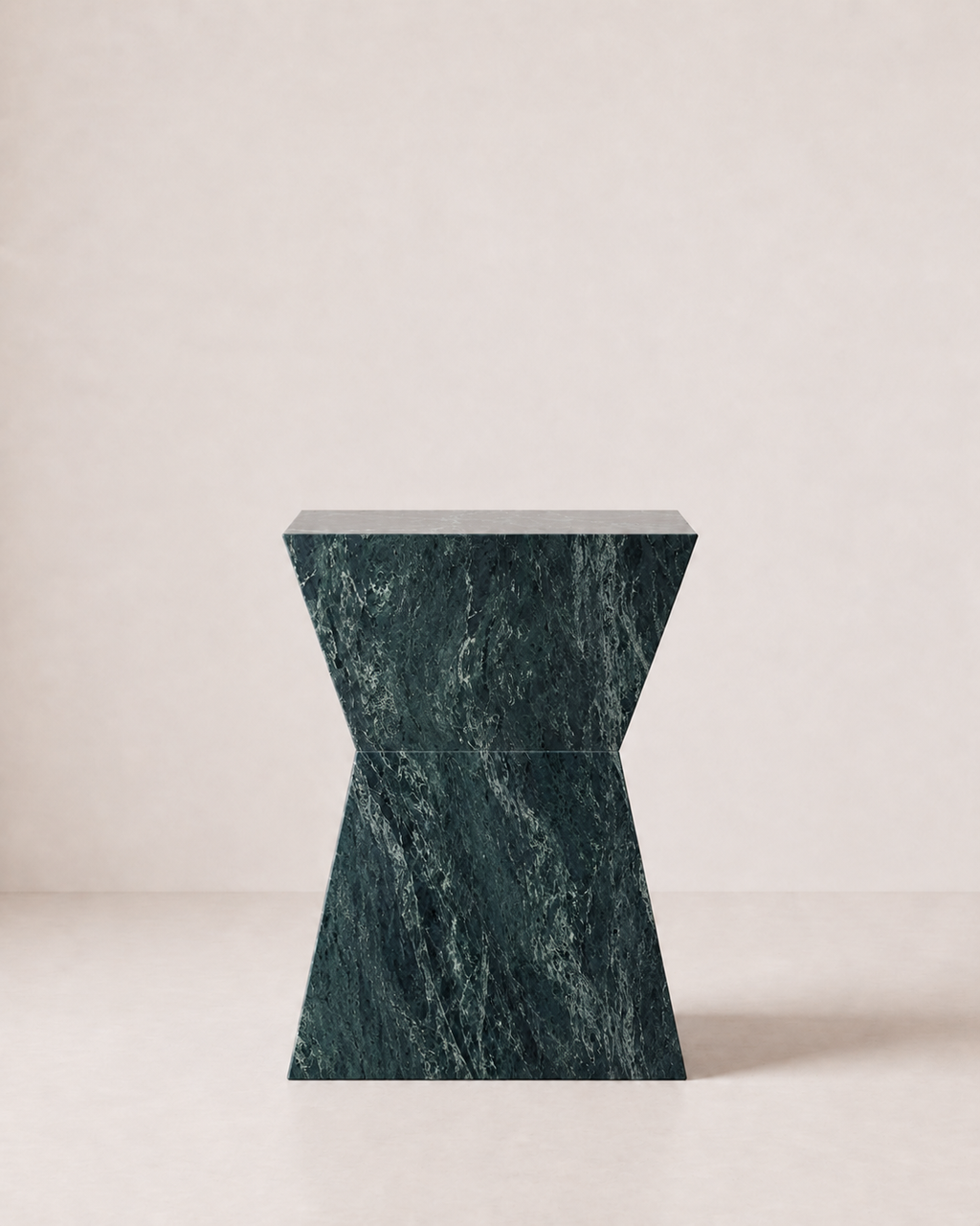 Hourglass shaped marble side table, made of luxury emerald green marble with delicate white veining, placed in a light beige studio. Front view.