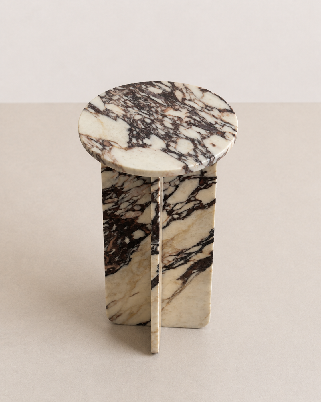 Luxury cream marble with deep violet veining pattern round side table in a off white studio background. Angled view.