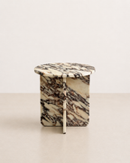 A luxury cream marble with delicate deep violet veining pattern round side table in a off white studio background. Front view.