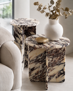 A set of two luxury cream marble with deep violet veining pattern round side tables placed next to a linen couch in a modern Australian living room. Aesthetic lifestyle. 