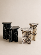 Editorial of two sets of luxury marble round side tables in a off white studio background. 