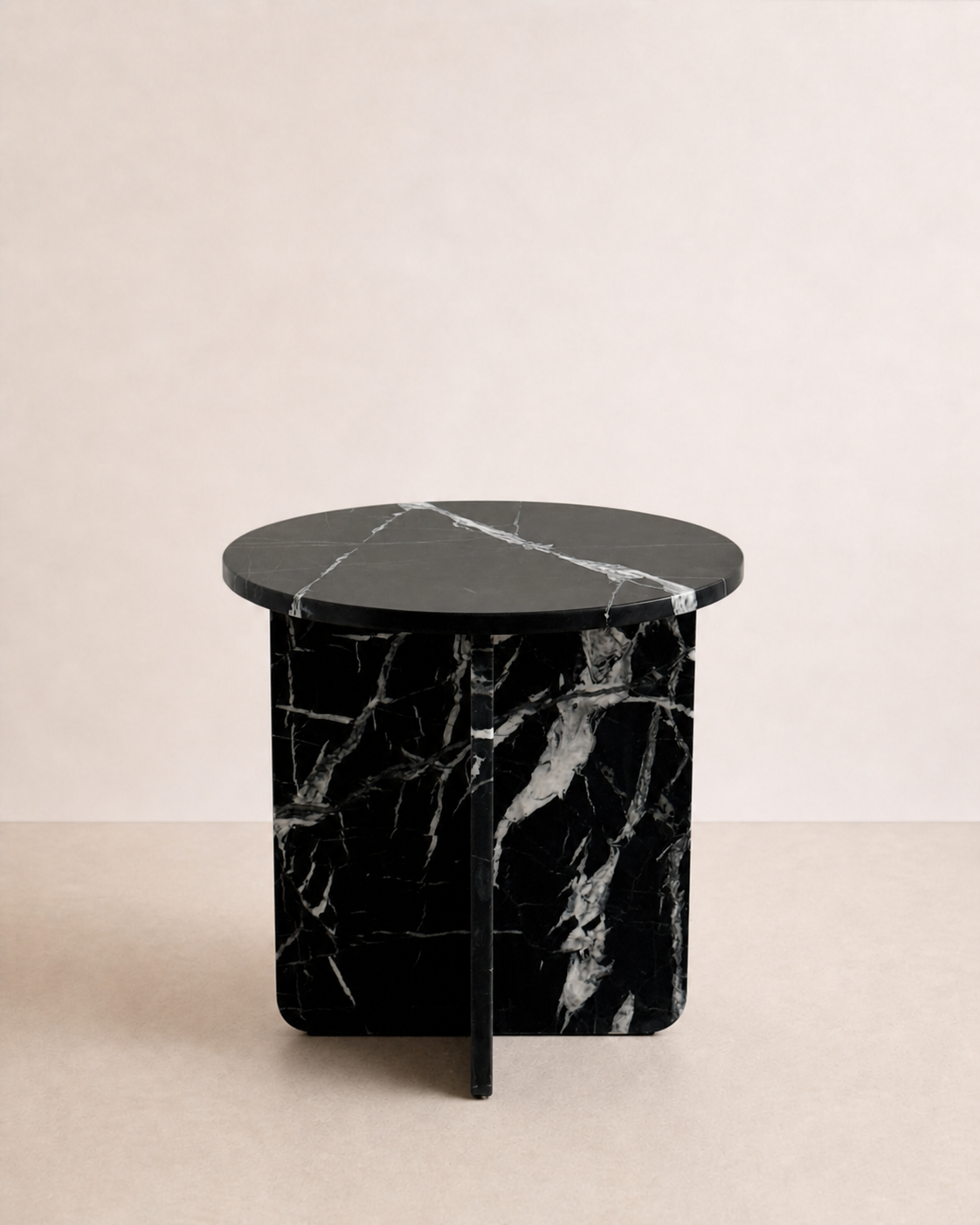 A luxury black marble with delicate white veining pattern round side table in a off white studio background. Front view.