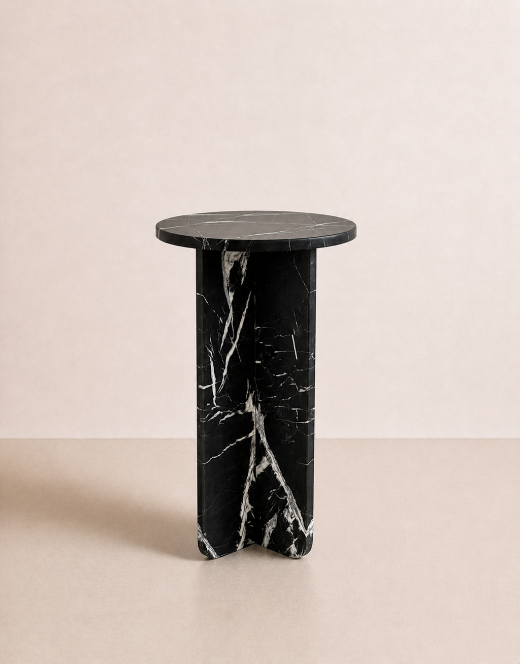 A luxury black marble with delicate white veining pattern round side table in a off white studio background. Side view.