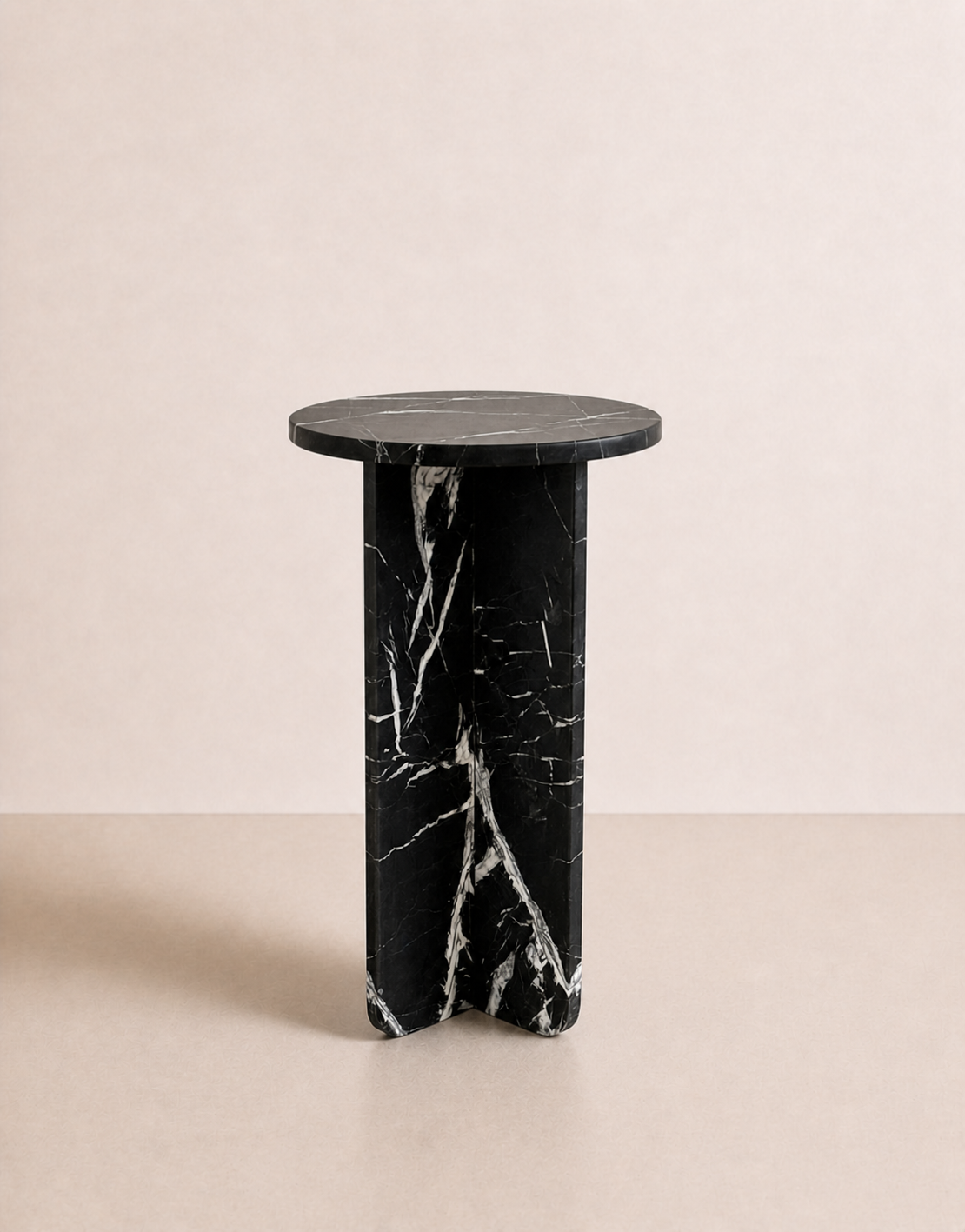 A luxury black marble with delicate white veining pattern round side table in a off white studio background. Side view.